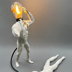 Sculpted human figure with a lightbulb for a head